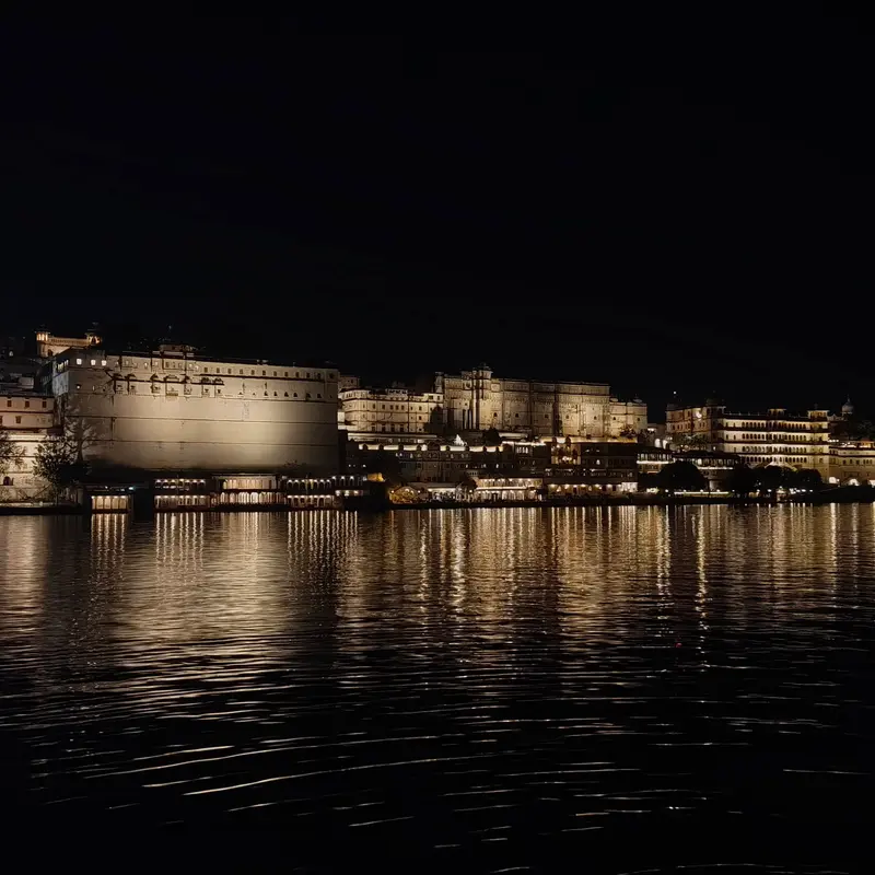 The City Palace lit up across Lake Pichola at night